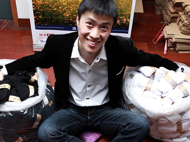 2011 年，陈伯乐坐在仓库里那批袜子旁边
